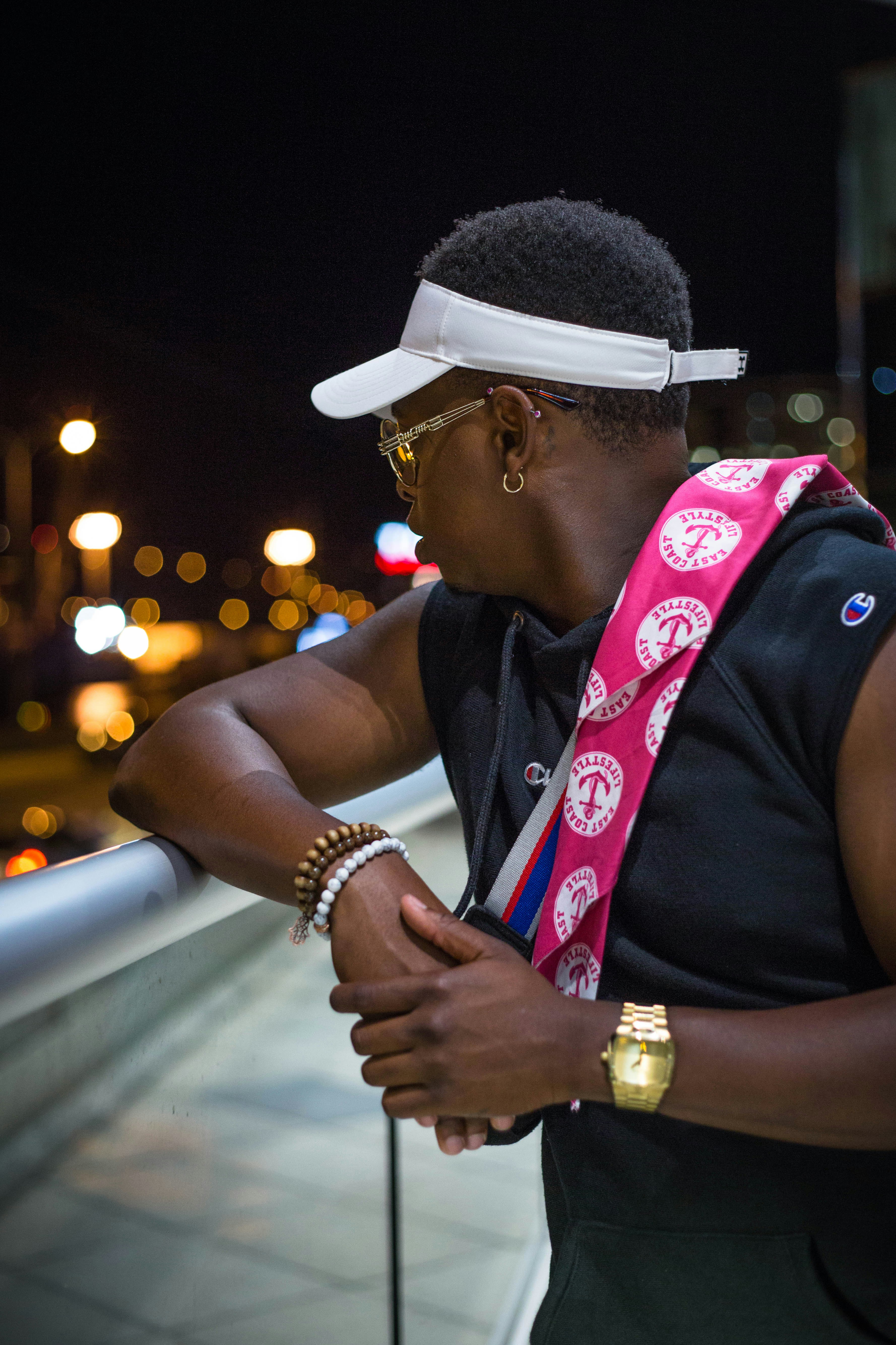 man in black vest wearing white hat and gold watch